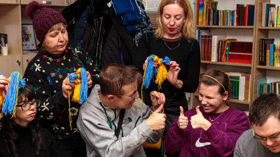 The Caritas center in Kryvyi Rih provides distraction. The women exchange ideas and make dolls in Ukrainian colors with their children with disabilities.