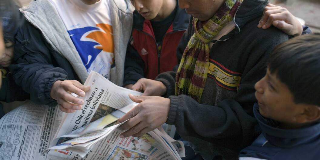 Jugendliche informieren sich in der Zeitung.